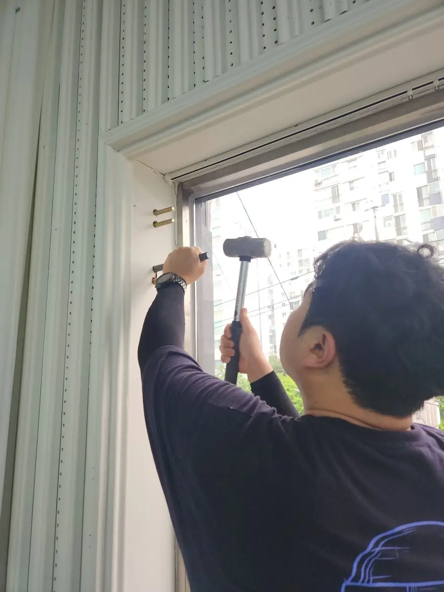완강기 설치 진행 중 복도형 큰 창이 있는 실내 공간