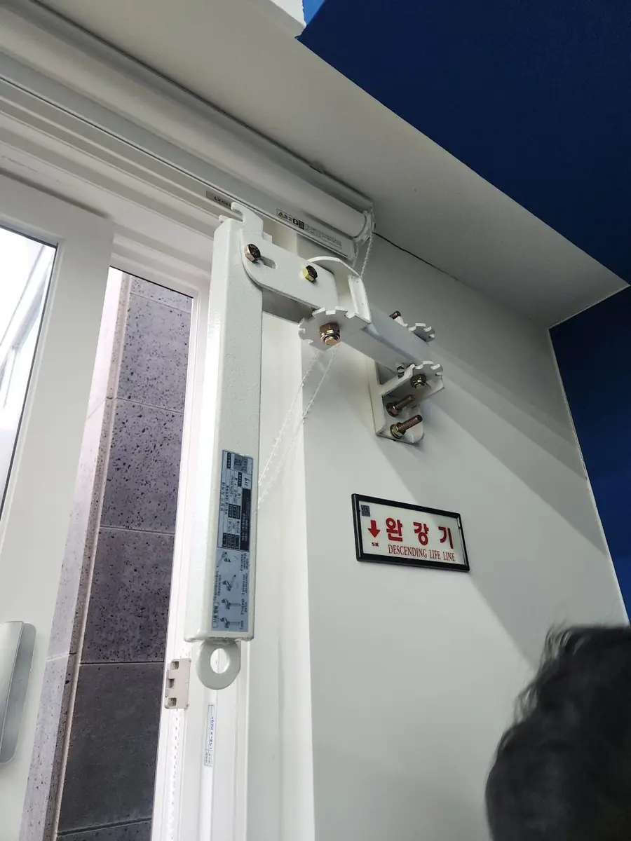 완강기 설치 진행 중 롤블라인드가 달린 창가